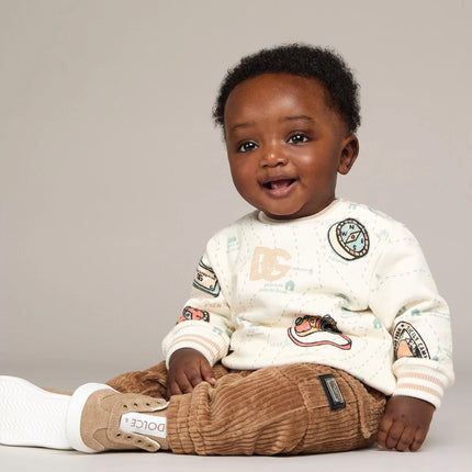 boy wearing baby clothing from kids atelier posing in desert promoting end of season sale 
