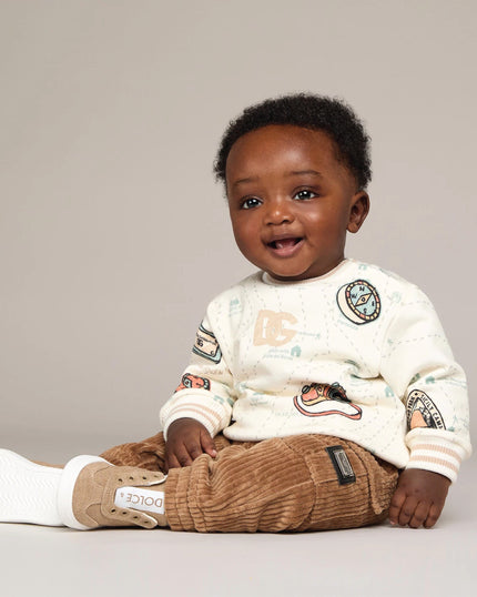 boy wearing baby clothing from kids atelier posing in desert promoting end of season sale 