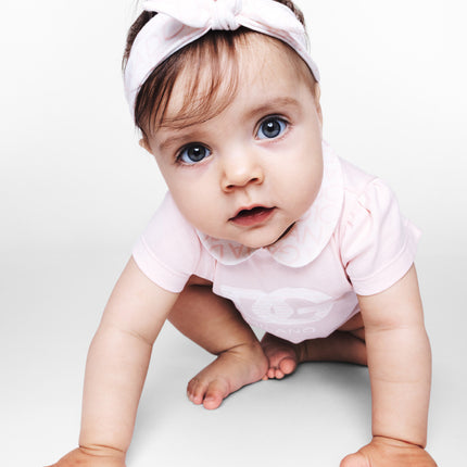 girl wearing baby clothing from kids atelier posing in desert promoting end of season sale 