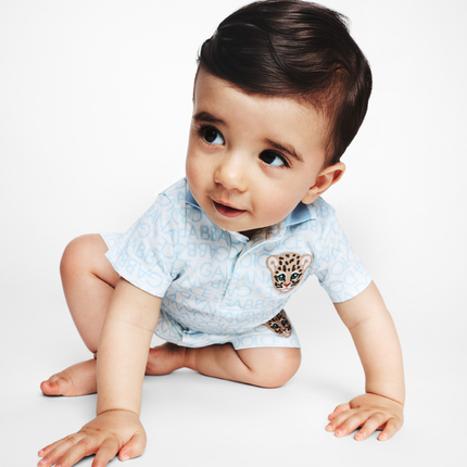 boy wearing baby clothing from kids atelier posing in desert promoting end of season sale 