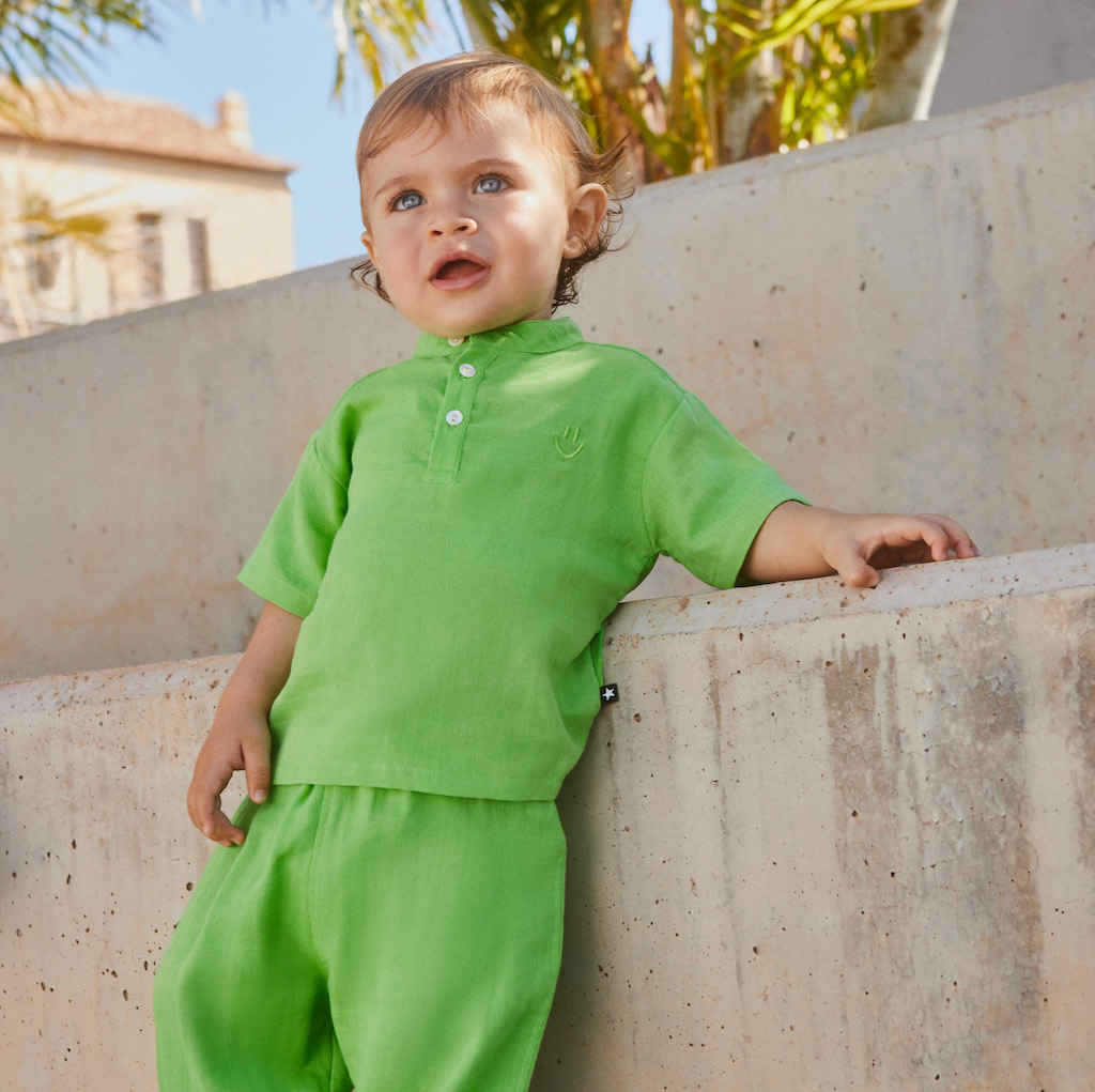 boy wearing baby clothing from kids atelier posing in desert promoting end of season sale 