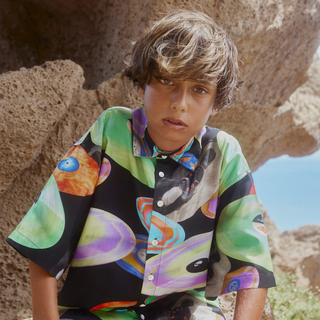 boy wearing clothing from kids atelier posing in desert promoting end of season sale 